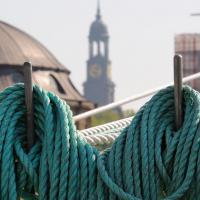 4600_2781 Aufgeschossene Schiffstaue an der Reeling eines Seglers; Turm des Hamburger Michels. | Hafengeburtstag Hamburg - groesstes Hafenfest der Welt